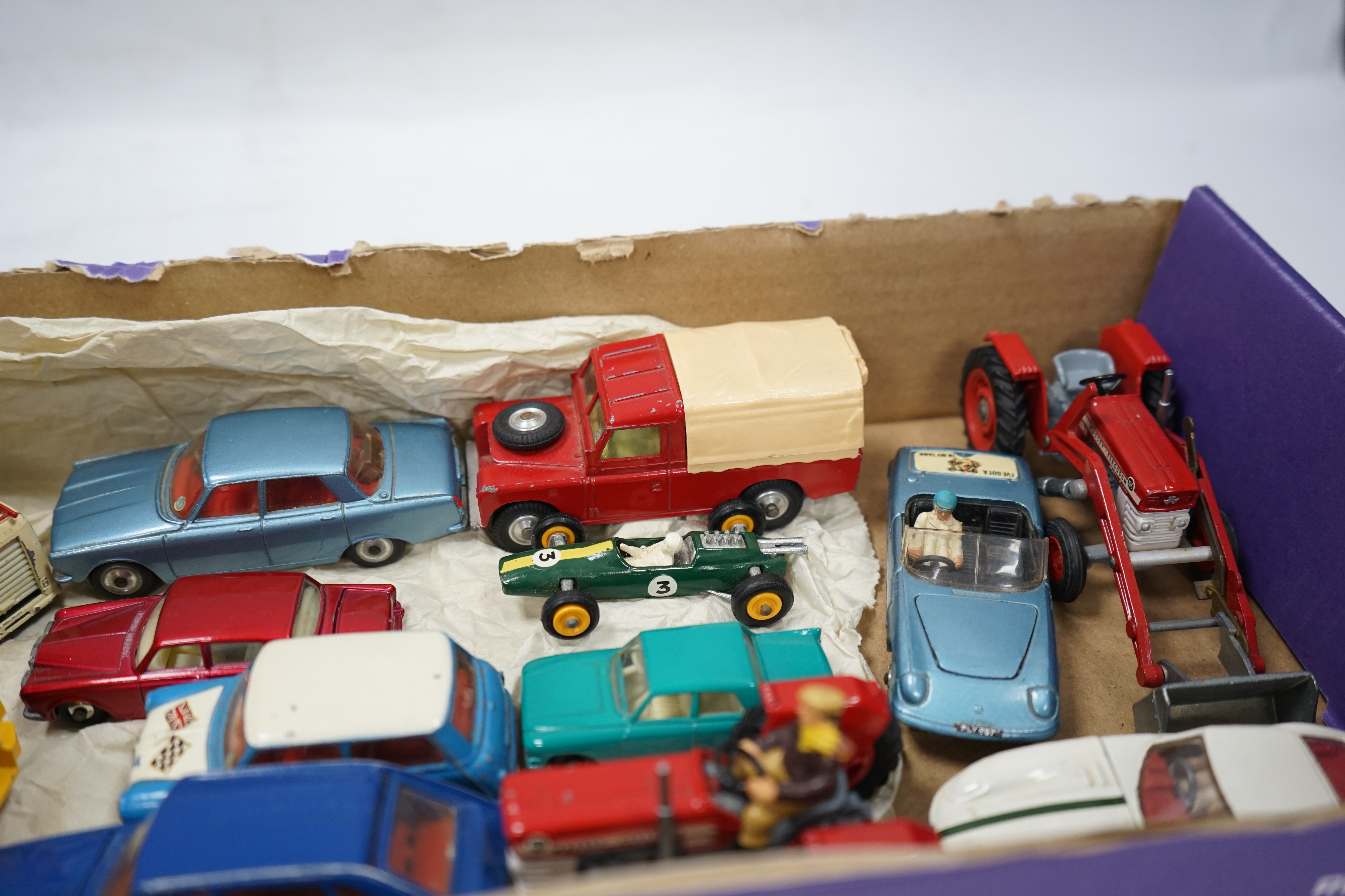 A collection of Corgi Toys and Matchbox series diecast vehicles, including a Lotus Elan 2, with ‘Tiger In My Tank’ decal, a Volvo P1800, Morris Mini Cooper, a Land Rover, a Rover 2000, a Massey Ferguson tractor shovel, e